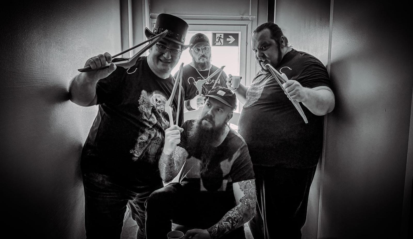 CaRage backstage, four band members posing with clothes hangers